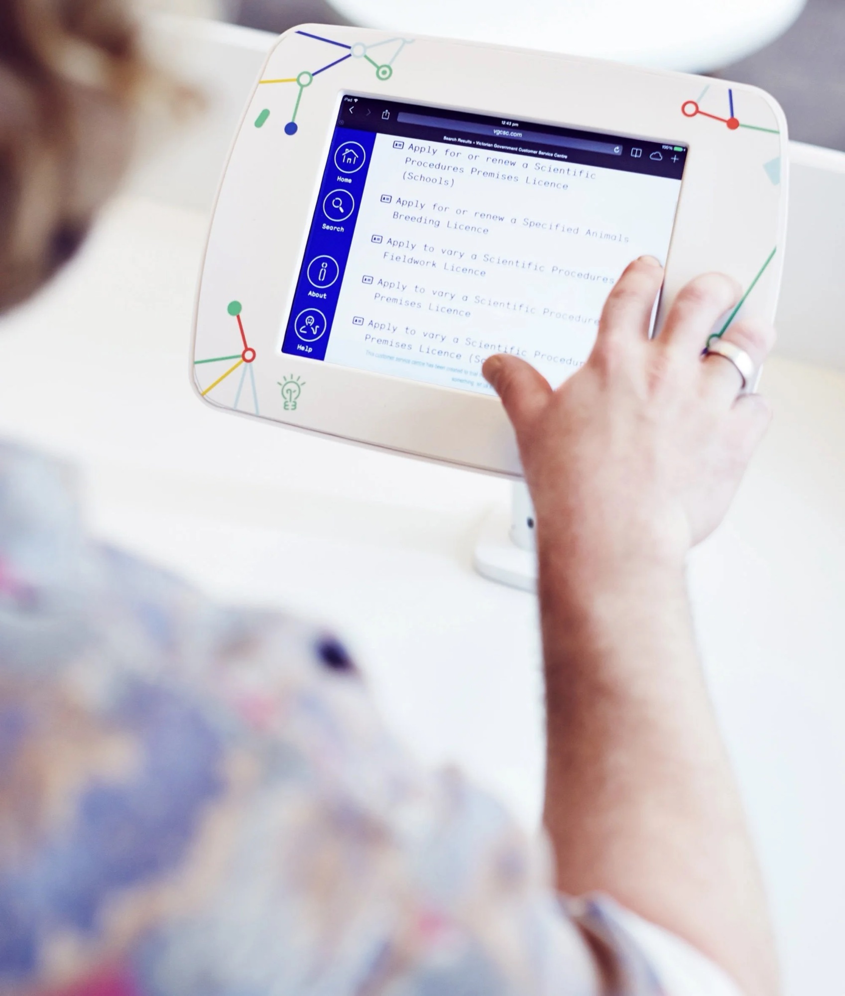 A visitor using a branded tablet to search for a licence in the concept service centre.
